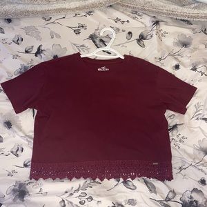 Cropped burgundy Hollister t-shirt. Size small. Thick lacey detail on bottom.